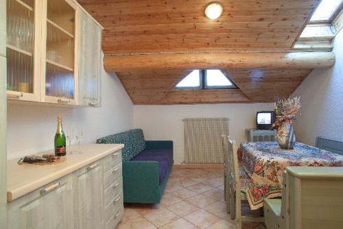 利维尼奥VERDELAGO Appartamenti e CASA CRY的客厅配有沙发和一张桌子及一瓶葡萄酒