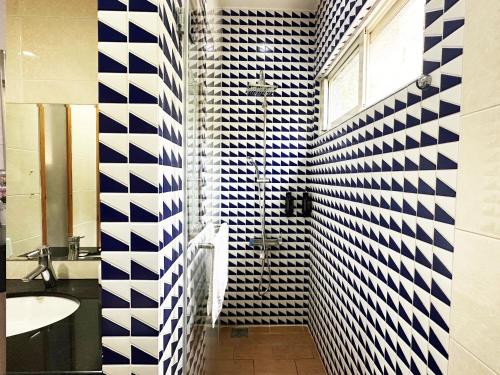 横山登美山庄的浴室拥有蓝色和白色的瓷砖墙壁和水槽