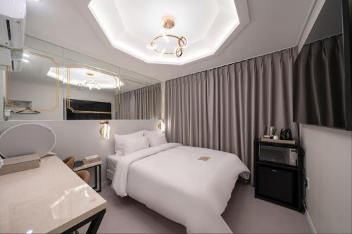 仁川市DK Incheon airport hotel的酒店客房配有白色的床和镜子
