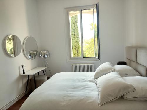 蒙彼利埃Bastide Castella的白色的卧室设有一张大床和一个窗户