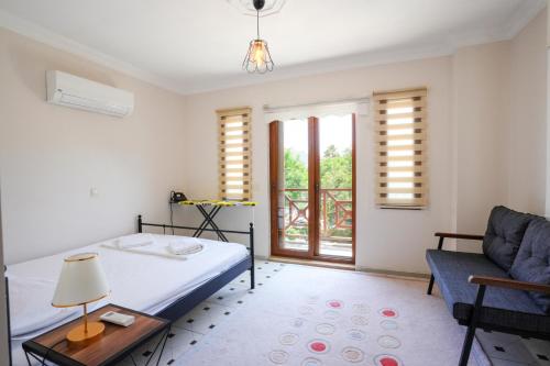 奥尔塔贾Villa w Pool and Balcony 3 min to Dalyan River的一间卧室配有一张床、一张沙发和一个窗口