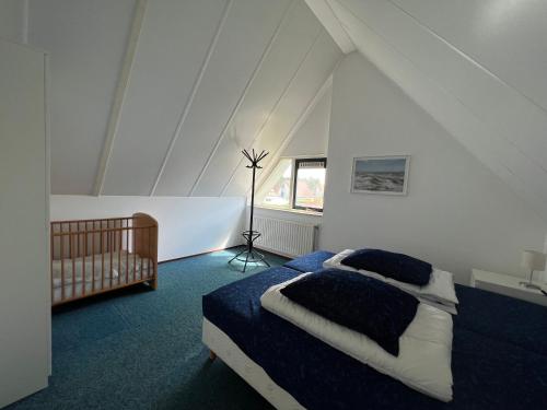 布雷斯肯斯Hello Zeeland - Vakantiehuis Stern 207的阁楼上的卧室配有一张床和一张婴儿床