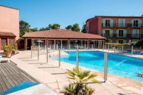 穆昂萨尔图French Riviera Lodge, A/C, swimming pool, parking的一座游泳池,毗邻一座建筑,设有凉亭