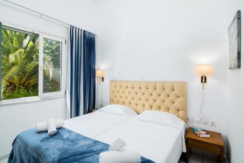 古维亚Helion Resort的一间卧室设有两张床和窗户。