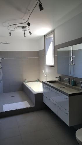 蒙彼利埃VILLA MONTPELLIER的白色的浴室设有水槽和浴缸。