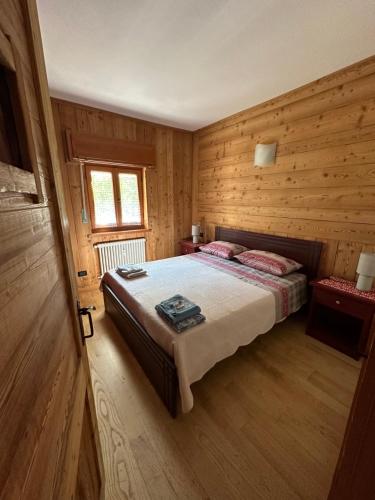 利莫内皮埃蒙特Casa Olivera的木制客房内的一间卧室,配有一张床