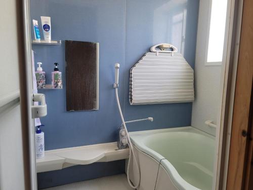对马市하루카오후나에 민숙的蓝色的浴室设有浴缸和水槽
