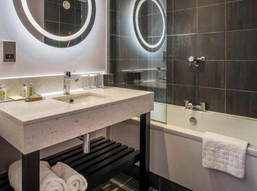 亚顿双树希尔顿布里斯托尔南部-凯德伯里别墅酒店的浴室配有盥洗盆和浴缸。