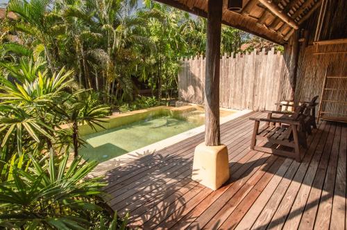 库德岛旺季泳池别墅& Spa的木甲板,配有野餐桌和游泳池