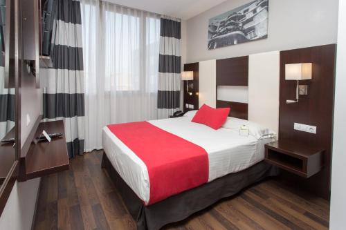 巴塞罗那奥林匹克套房酒店及Spa别墅的酒店客房设有一张带红色枕头的大床