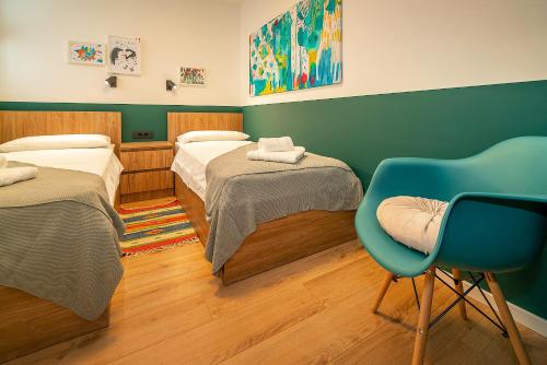 万塔西西Apartment Noa on island Krk的一间设有两张床和一张蓝色椅子的房间