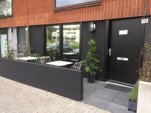 霍夫多普Near Amsterdam and airport, 90m2, privacy!的大楼前设有桌椅的餐厅