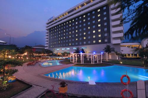 井里汶ASTON Cirebon Hotel and Convention Center的大楼前设有游泳池的酒店