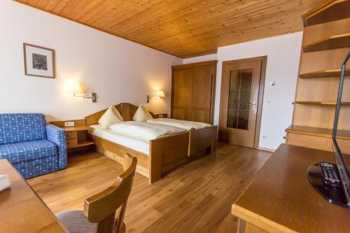 巴德小基希海姆Appartments Bergland的酒店客房,配有床和蓝色的沙发