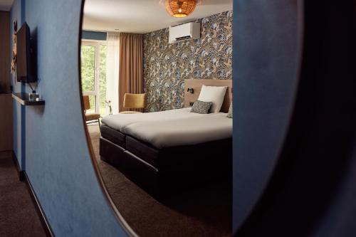 德科赫Van der Valk Texel - De Koog的酒店客房,配有床和镜子