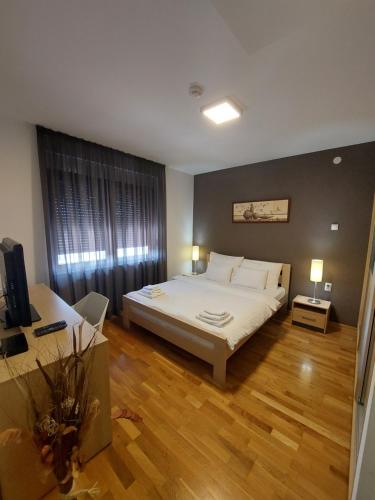 Srpski ItebejMotel MS的卧室配有一张白色的大床,铺有木地板