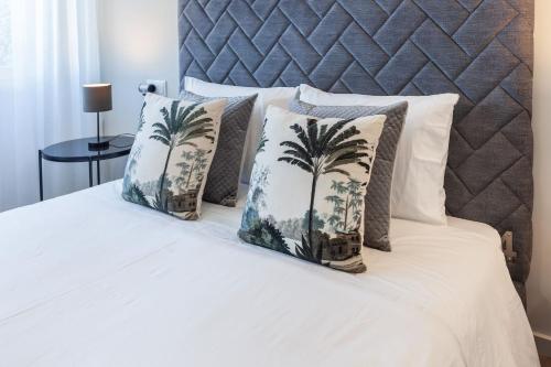 布拉加ALL4Braga - Minho's Guest的一张带四个枕头的床,上面有棕榈树