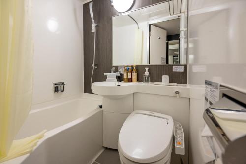 鹿儿岛Kagoshima Plaza Hotel Tenmonkan的一间带卫生间、水槽和镜子的浴室