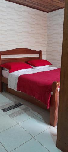 佩尼多Cantinho do Rio的一张位于一间红色和白色毯子的房间的床铺