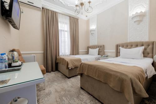 撒马尔罕Hotel Billuri Sitora的酒店客房设有两张床和电视。