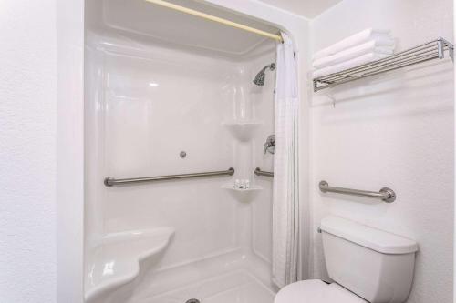奥兰多Ramada by Wyndham Altamonte Springs Near I-4的白色的浴室设有卫生间和淋浴。