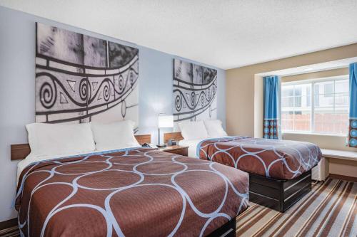 乔利埃特Super 8 by Wyndham Joliet的酒店客房设有两张床和窗户。