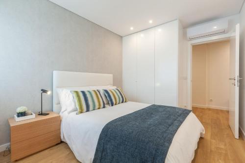 布拉加Art's Braga Apartment - Minho's Guest的卧室配有白色的床和木制梳妆台。