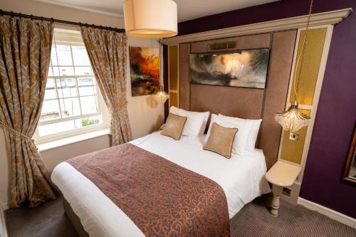 亚特Cross Hands Hotel by Greene King Inns的一间设有大床和窗户的酒店客房