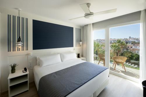 马翁加泰罗尼亚港瞭望台酒店的白色的卧室设有床和大窗户