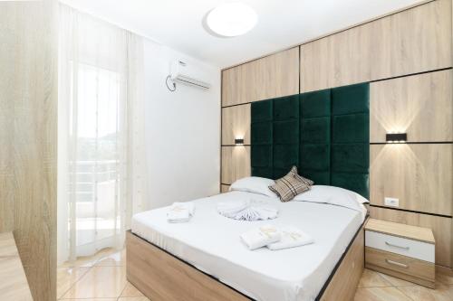 乌尔齐尼帕戈酒店的一间卧室配有一张大床和绿色床头板