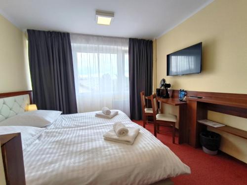 凯尔采Hotel SiLL的配有一张床和一张书桌的酒店客房