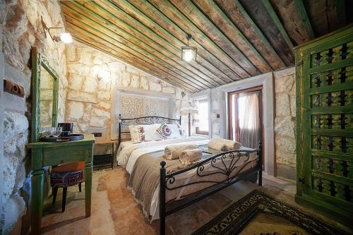 AvcılarAysel Inn House的一间卧室设有一张床和石墙