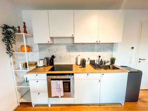 梅明根theSunset Club - STUDIO Küche - Balkon - Parken的厨房配有白色橱柜和炉灶烤箱。