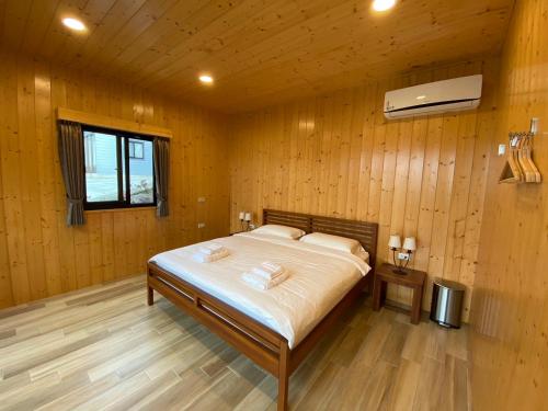 南庄乡云彩露营屋的卧室配有木墙内的一张床