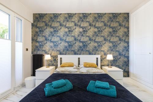 昂蒂布St George的一间卧室配有一张大床和两个蓝色枕头