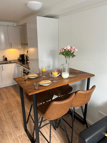 诺德韦克Noordwijk BB228的厨房配有带椅子和鲜花的木桌