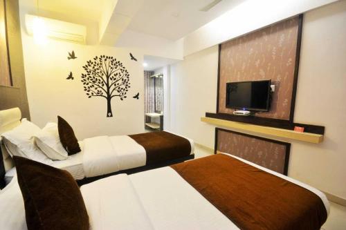钦奈AN STAYS Chennai Airport的一间酒店客房,设有两张床和电视