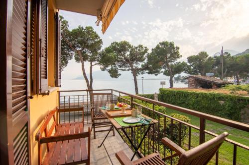 多马索Appartamento Lungolago的阳台配有桌椅,享有水景。