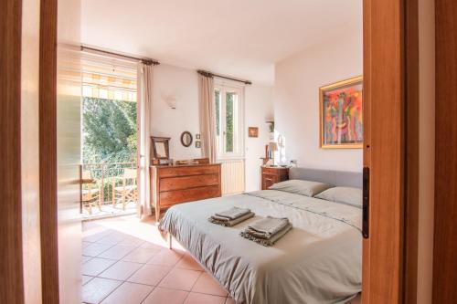 多马索Appartamento Lungolago的一间卧室设有一张床和一个大窗户