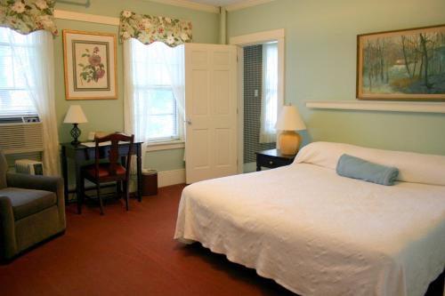 白河交界处柯立芝酒店的一间卧室配有一张床、一把椅子和窗户。