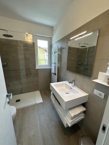 多马索Resort le Vele Suites and Apartments的一间带水槽、卫生间和镜子的浴室