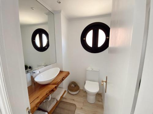 柯米拉斯Apartamento Nuria Comillas的一间带水槽、卫生间和两面镜子的浴室