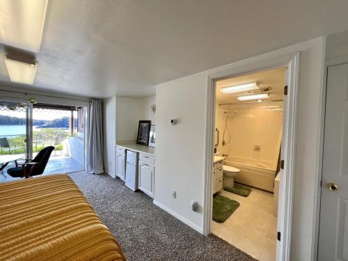 科迪亚克The Captains View - Cliffside, Ocean Views的一间卧室配有一张床,浴室设有淋浴。
