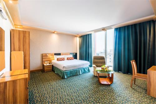 麦纳麦精英水晶酒店的酒店客房设有床和客厅。