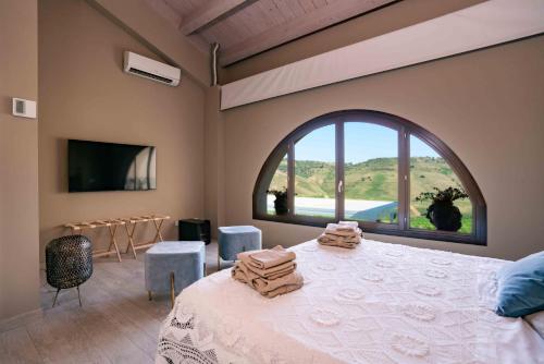 卡尔塔吉罗Judeka Agriresort的一间卧室设有一张床和一个大窗户