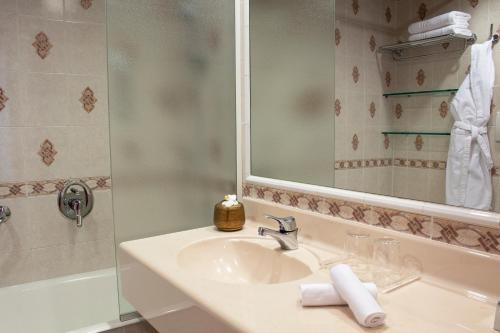 比森齐奥营韦斯普奇星际酒店的浴室配有盥洗盆和带镜子的淋浴