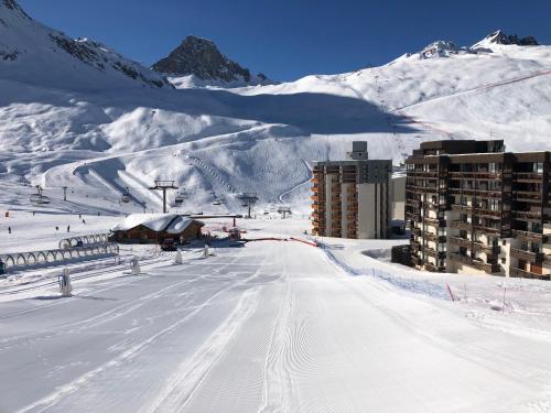 蒂涅Tignes : cocon luxueux au pied des pistes的一座白雪覆盖的山,有一座建筑和一个滑雪场