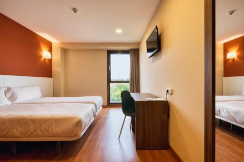 莫斯托雷斯Checkin Madrid Móstoles的酒店客房配有两张床和一张书桌
