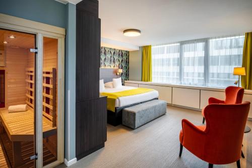 布鲁塞尔欧盟索恩酒店的酒店客房配有一张床、一张桌子和一把椅子。