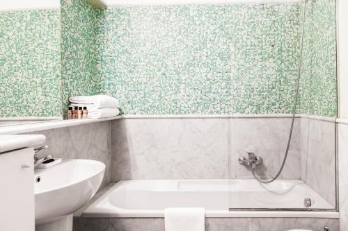 米兰布雷拉斯卡拉公寓的带淋浴、浴缸和盥洗盆的浴室